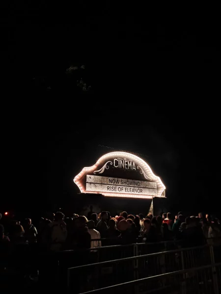 a crowd of people standing in front of a sign